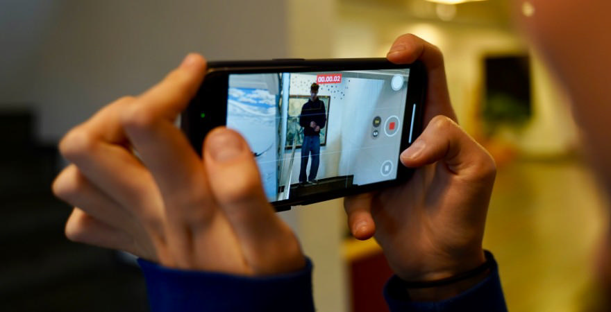 Hænder holder mobiltelefon, der optager video